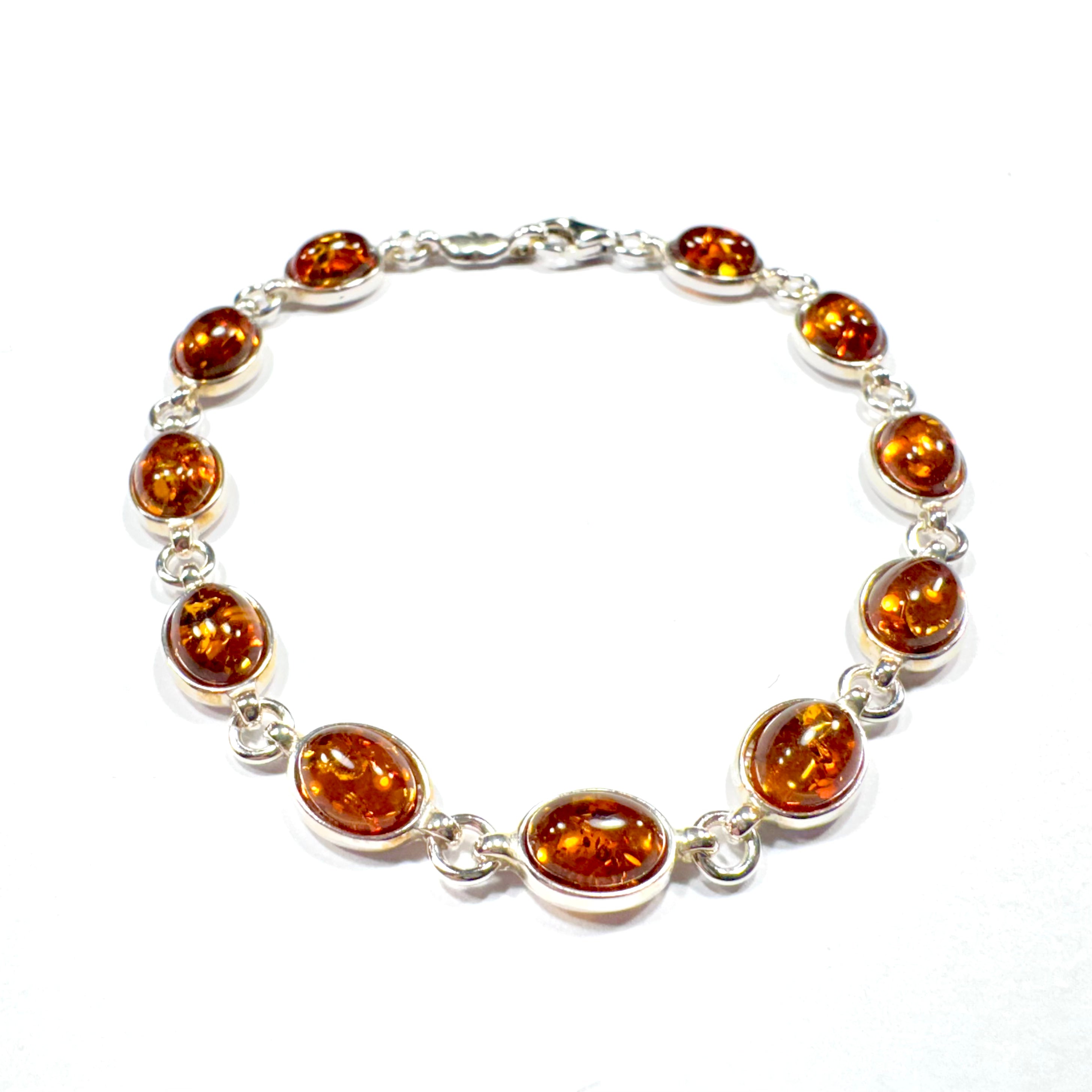 Luxuriöses Bernstein-Armband aus 925er Silber mit kunstvoll eingefassten Bernsteinen in warmen Naturtönen. Handgefertigtes Unikat mit sicherem Silberverschluss.