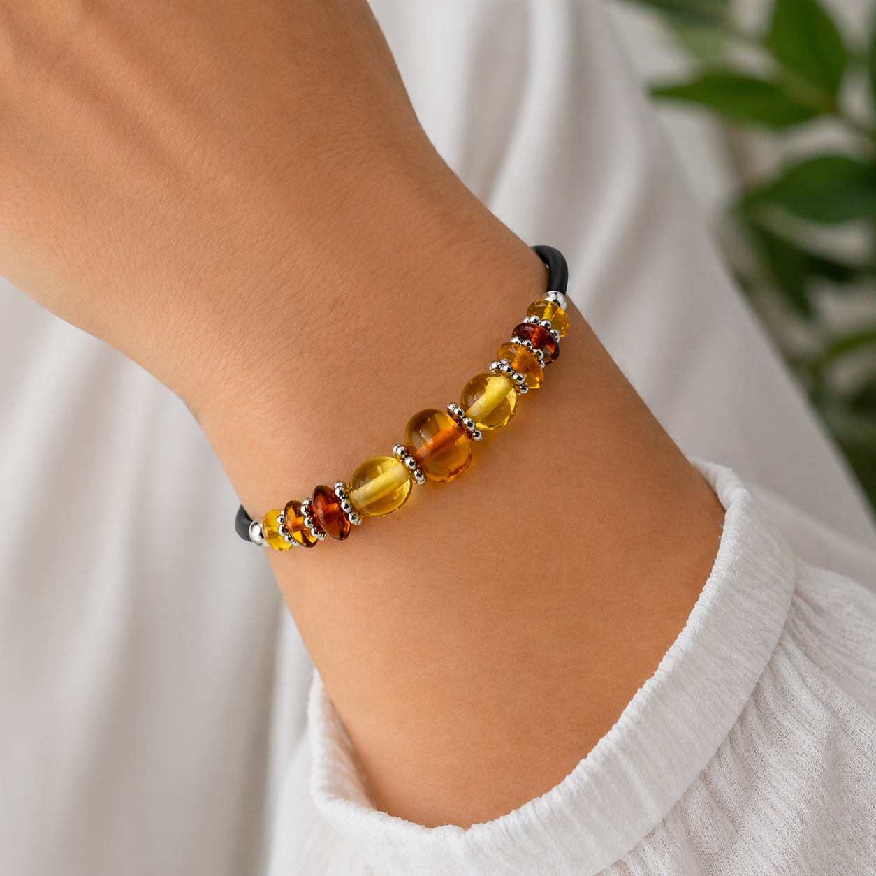 Modernes Bernstein Armband mit gelben und cognacfarbenen Perlen sowie silbernen Elementen am Handgelenk getragen