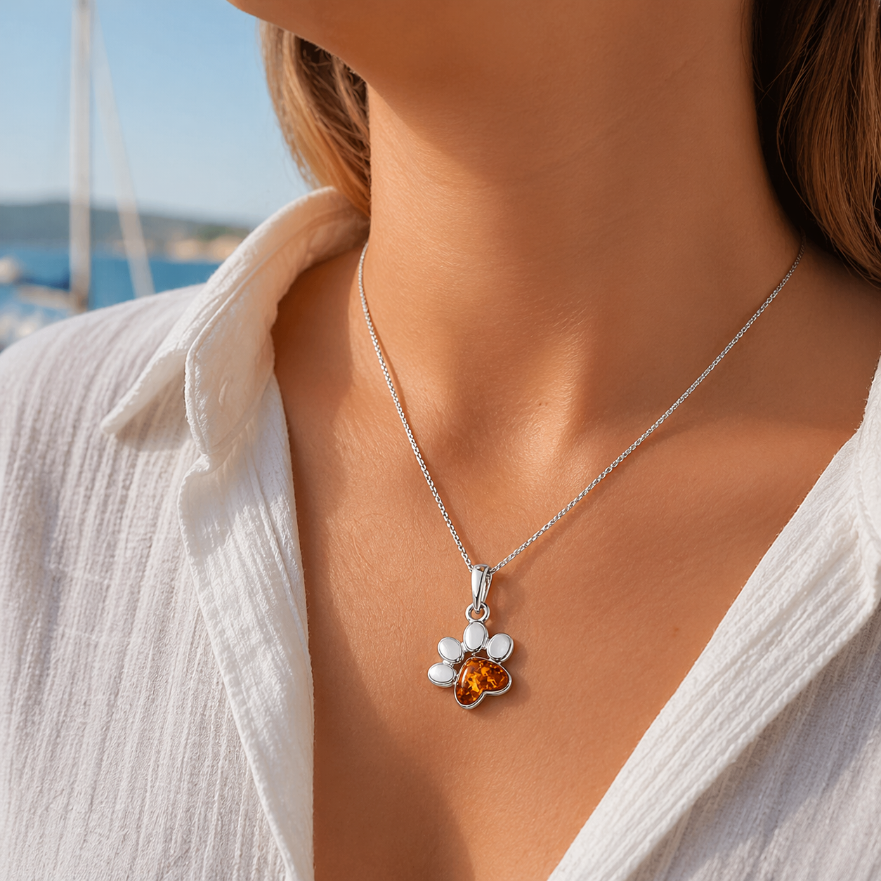 Frau trägt Bernstein Halskette mit Pfoten Anhänger aus Silber – maritimer Schmuck im Sommer Look