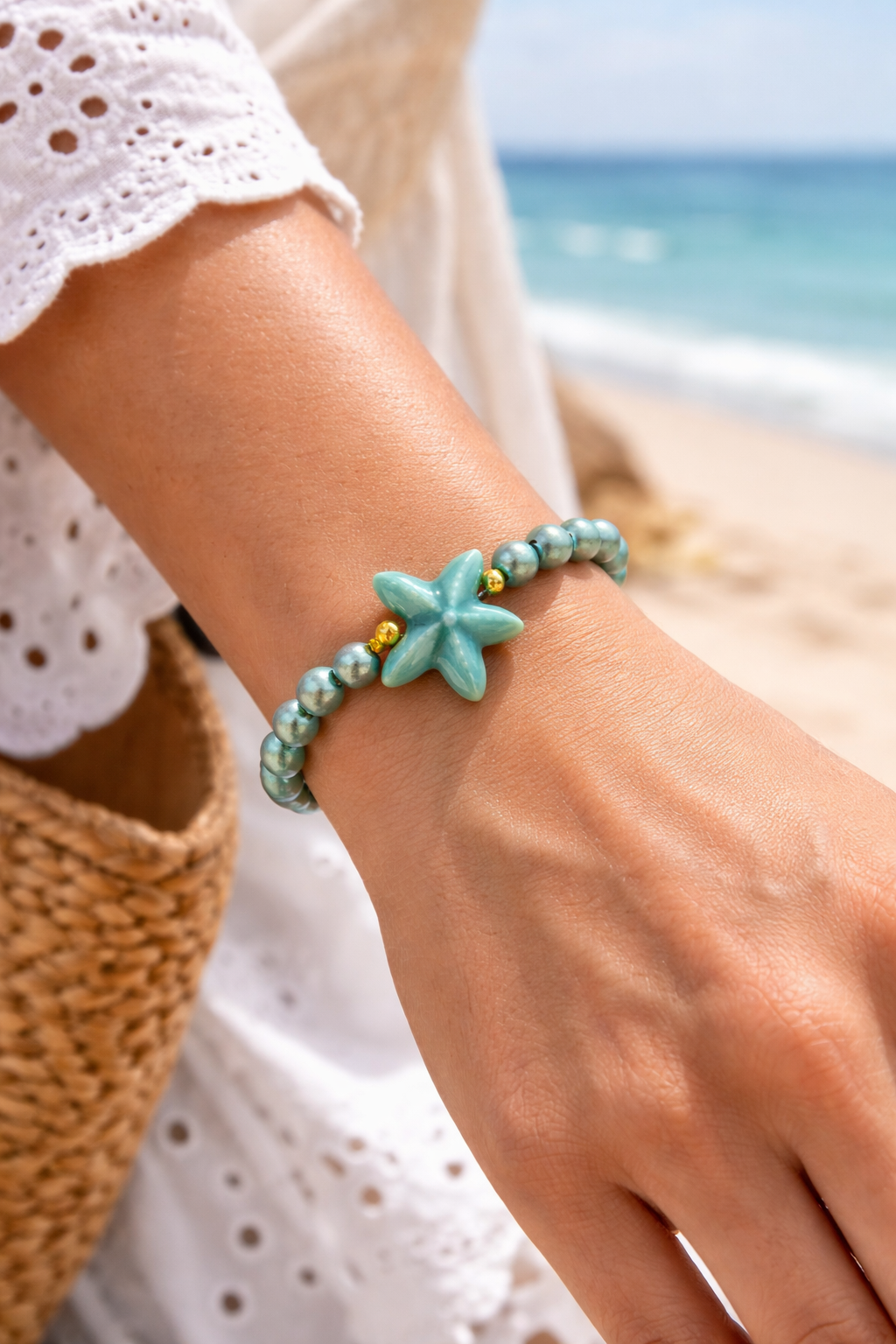 Türkises Perlenarmband mit Seestern und goldfarbenem biba Anhänger – elastisches Damenarmband Tragebild