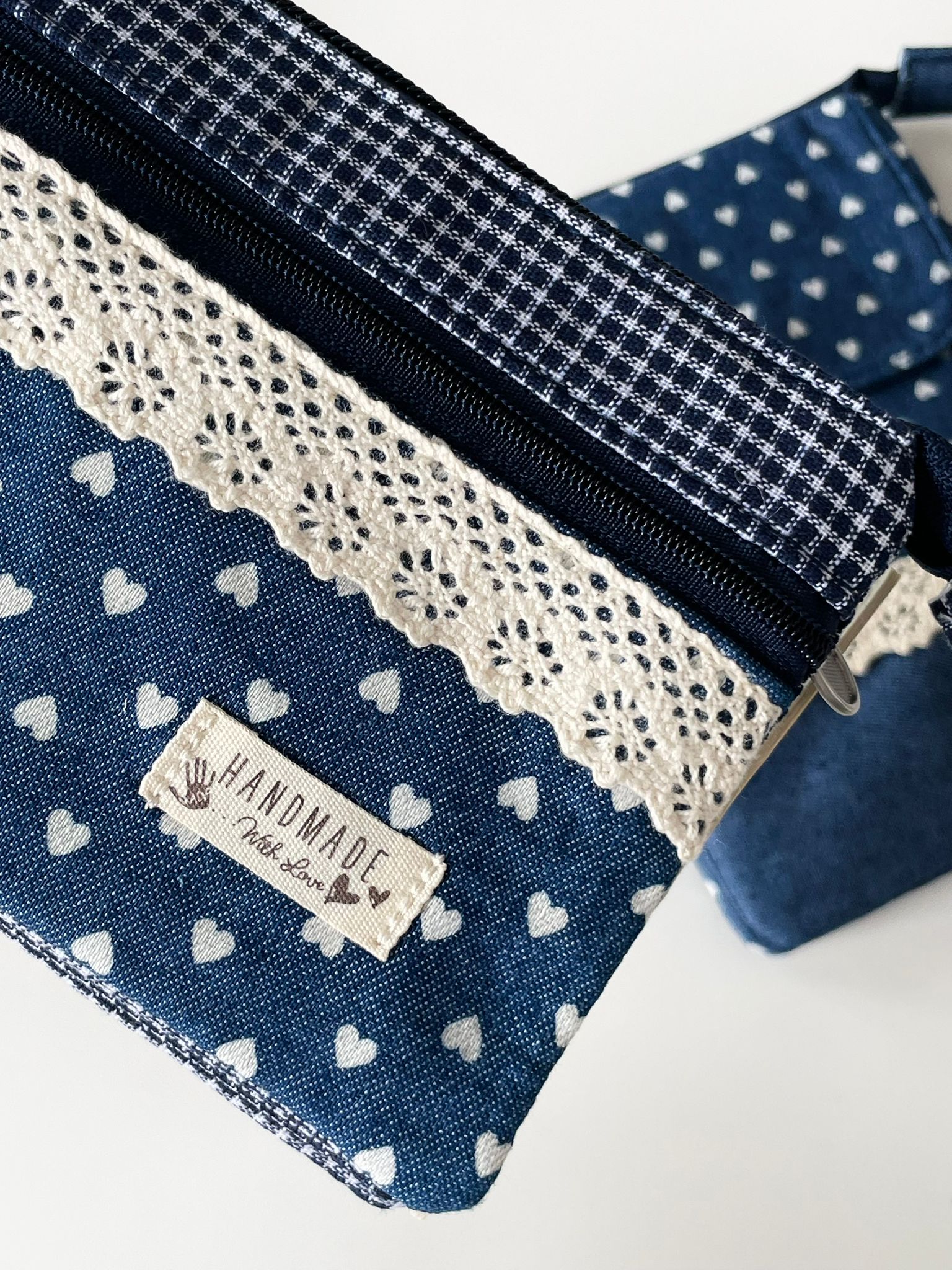 Handgemachtes Taschen-Set in Blau mit weißen Herzen, bestehend aus Schlüsselanhänger, Reißverschlusstasche und Umhängetasche mit Spitze.
