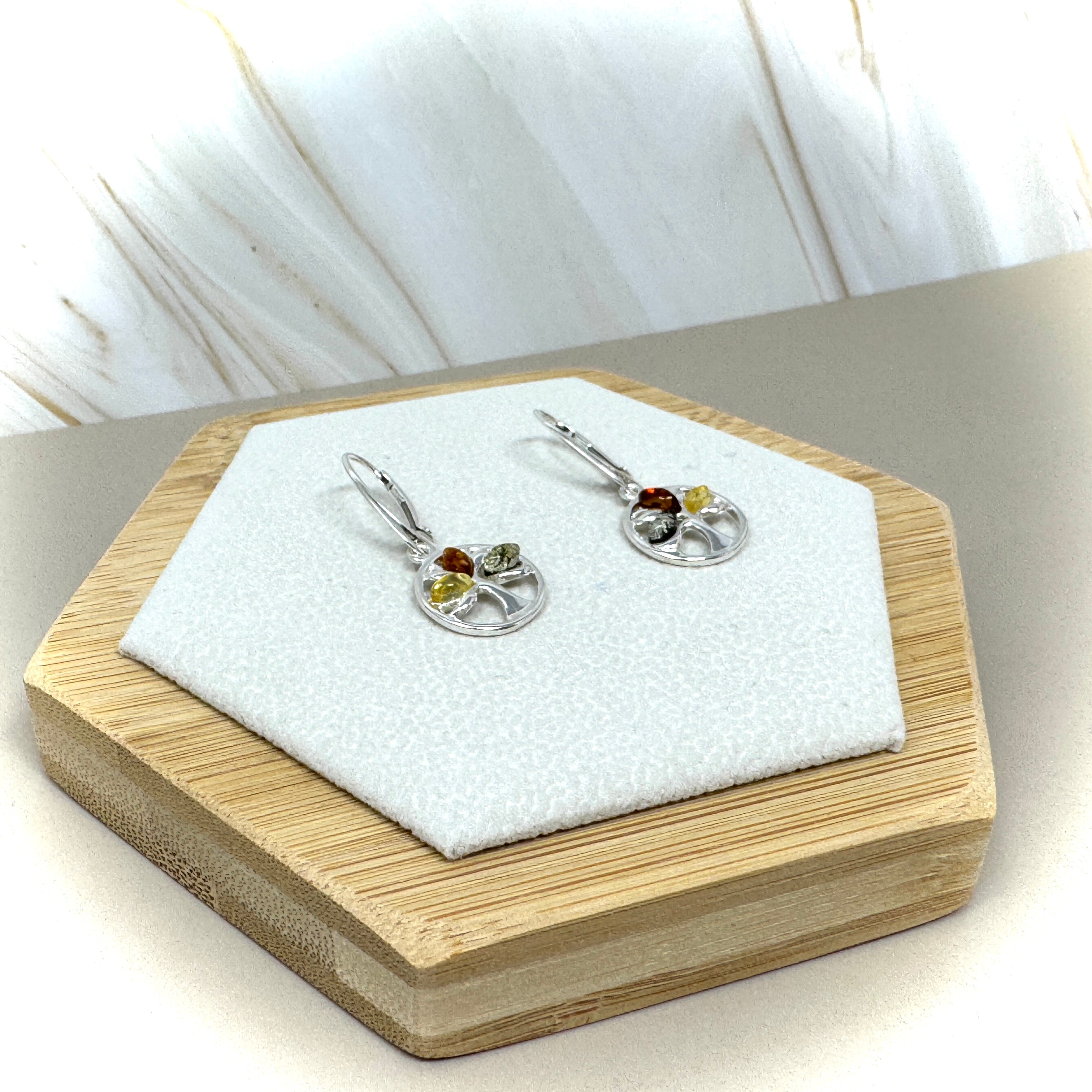 Paar silberne Ohrringe mit Lebensbaum-Motiv, verziert mit mehrfarbigem Bernstein in Rot, Gelb und Grün.