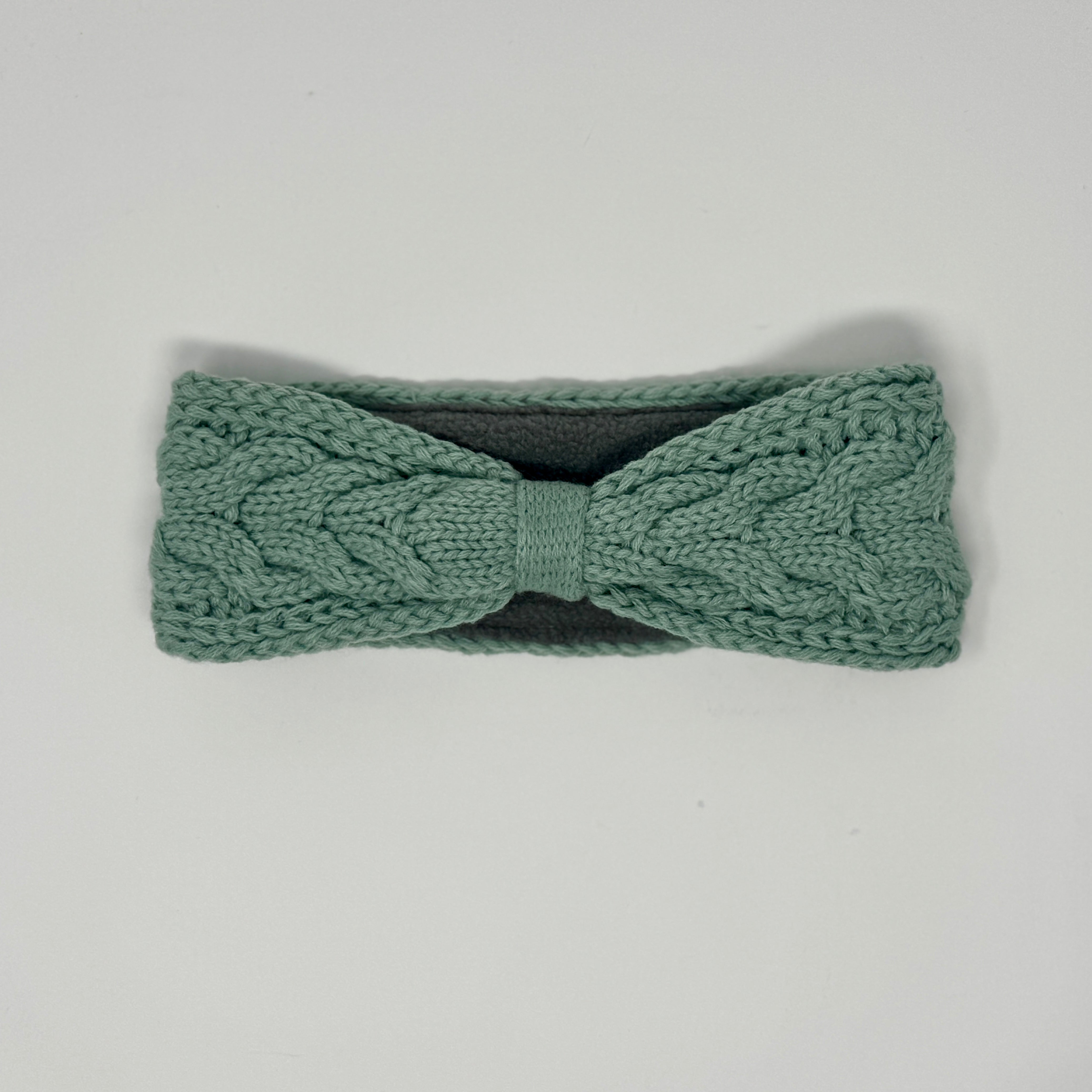 Mintgrünes gestricktes Stirnband mit Zopfmuster und Fleecefutter.