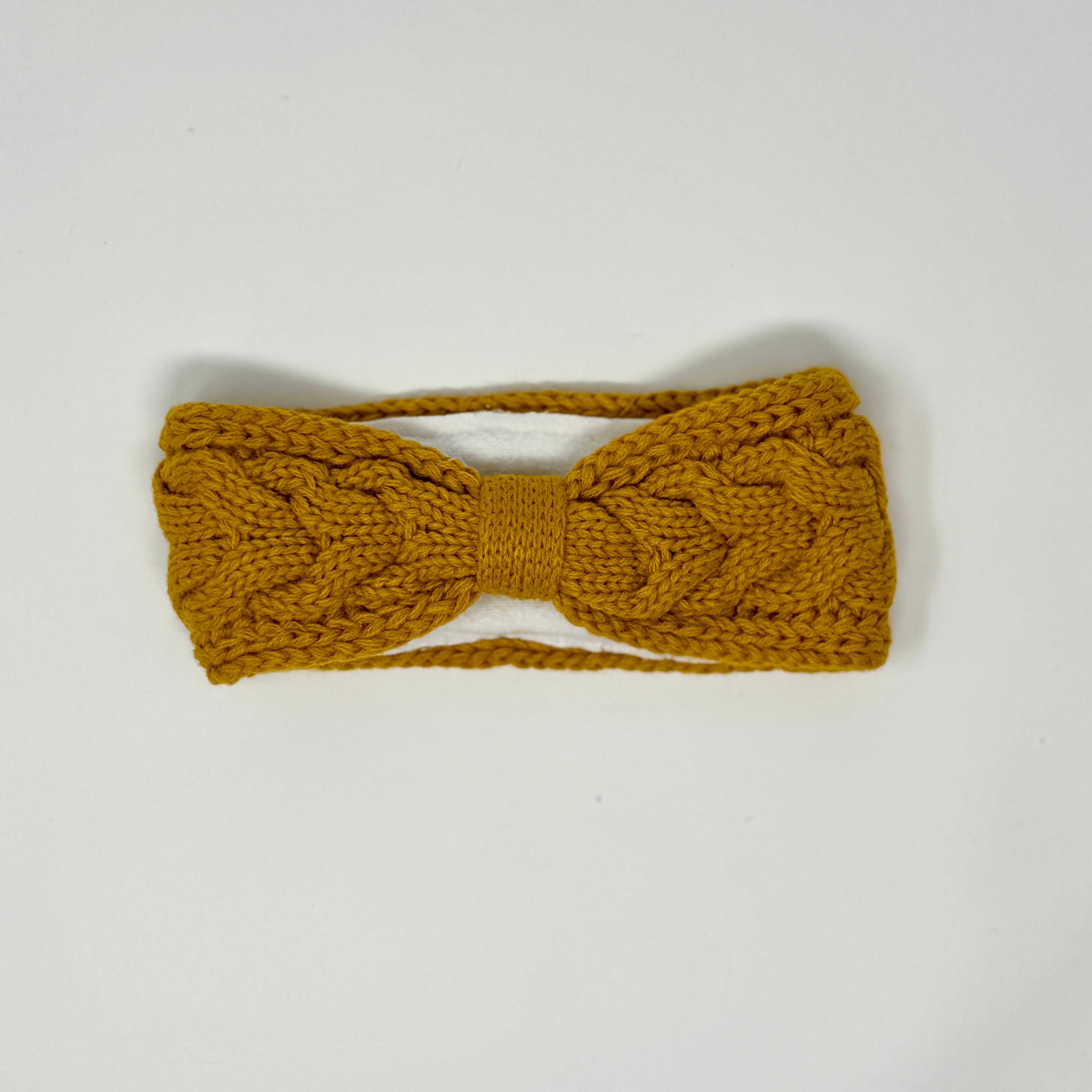 Senfgelbes gestricktes Stirnband mit Zopfmuster und Fleecefutter.