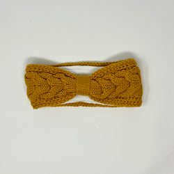 Senfgelbes gestricktes Stirnband mit Zopfmuster und Fleecefutter.