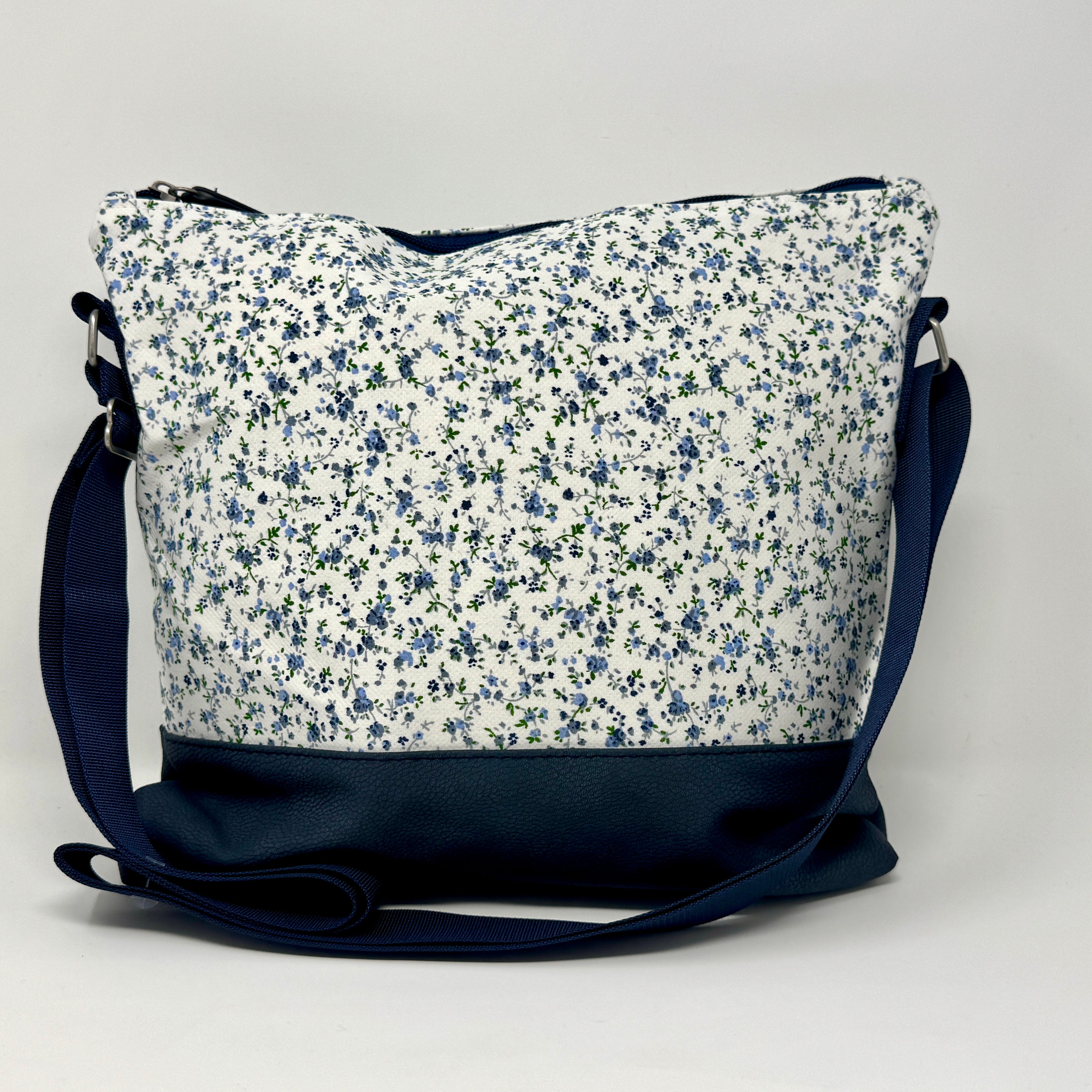 Umhängetasche aus Canvas mit blauem Blumenmuster und veganem Leder in Dunkelblau.