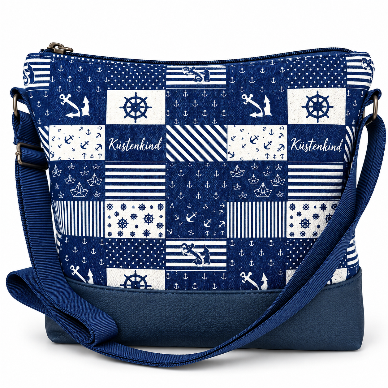 Dunkelblau-weiße maritime Umhängetasche Küstenkind mit Patchworkmuster, weißen Ankermotiven, Steuerrädern, Papierbooten und dunkelblauem Schultergurt.
