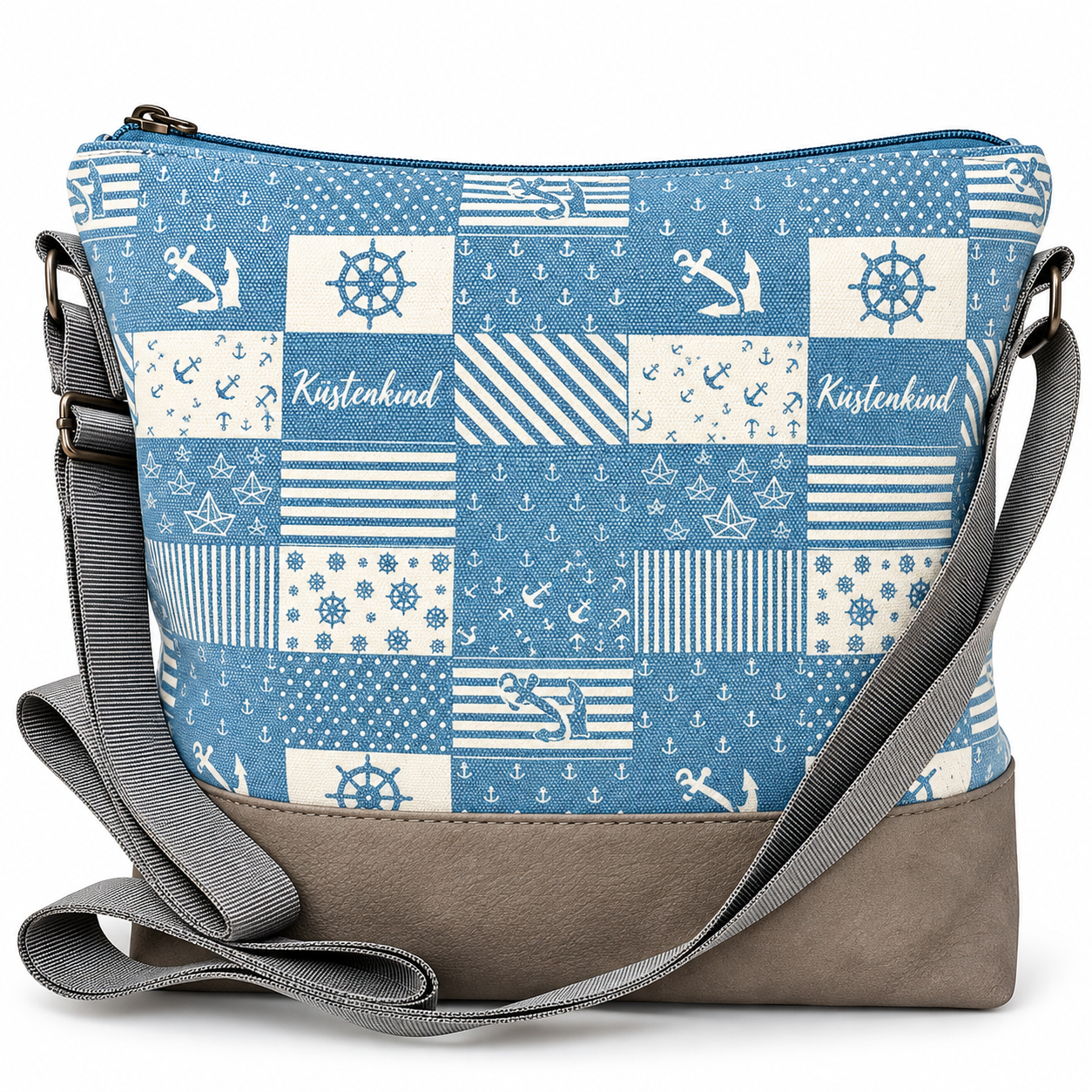Hellblau-weiße Küstenkind Umhängetasche mit maritimem Patchworkdesign aus Ankern, Steuerrädern, Papierbooten und Streifen, grauem Taschenboden und verstellbarem Schultergurt.